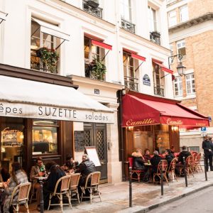 Franse straat met enkele café's en terrassen waar klanten eten en drinken